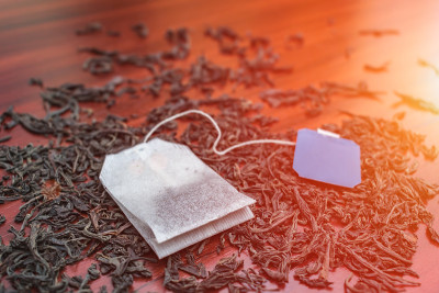 带标签的茶包，躺在早晨阳光下的大红茶叶子上