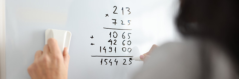女人在白板上添加数学数字