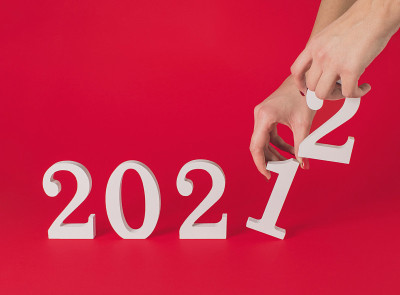 女性手中握着象征2021年开始过渡的数字。到2022年。红色背景上的水平构图与复制空间，最小的新年新