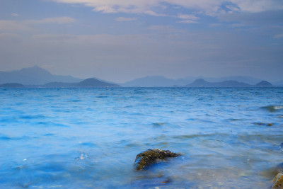 巨石从平静的海浪中伸出来