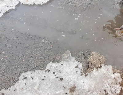 一个泥泞的水坑的纹理有雪，冰和碎片，春天融雪，户外小溪