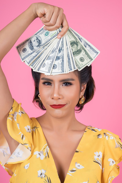 快乐时尚美女手握美元钞票