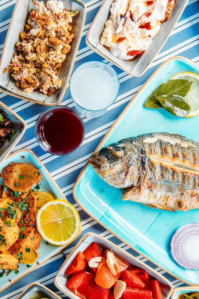 烤鱼、沙拉和蔬菜。海鲜，烤肉，meze, raki, ouzo，开胃菜和沙拉在希腊或土耳其鱼餐厅的桌