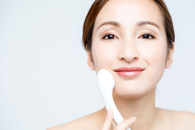 女人用手巧的离子导入仪。护肤概念。