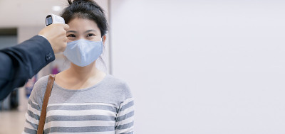 新常态卫士采用数字医疗电子体温计对百货公司亚洲女性顾客进行温度筛查，预防冠状病毒疾病传播
