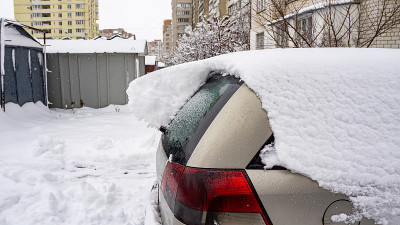 汽车上覆盖着厚厚的一层雪。大雪的负面后果。侧百辆不同图案的汽车。