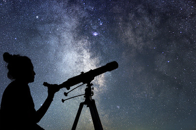 用望远镜看星星的女人。仰望星空的女人夜空