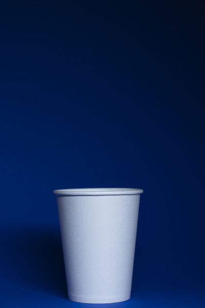 一个蓝色背景上的空白的白纸杯子