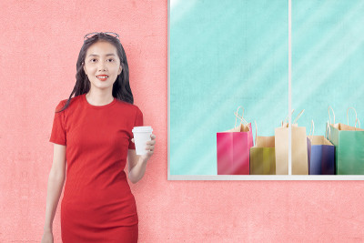 亚洲女人拿着咖啡杯和购物袋