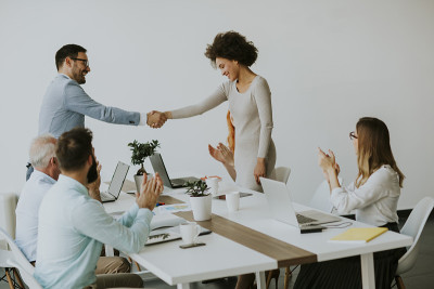 商人与他的女合伙人握手敲定一笔交易