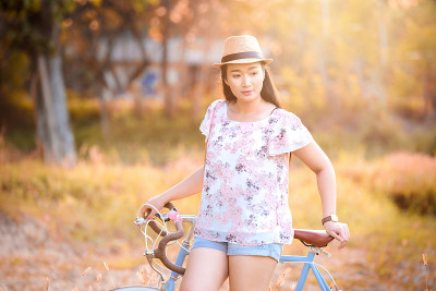 在花园里骑自行车的亚洲妇女。