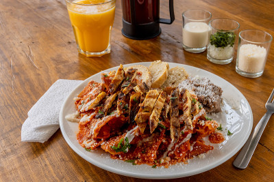 墨西哥传统的chilaquiles早餐绿色红莎莎橙汁木制