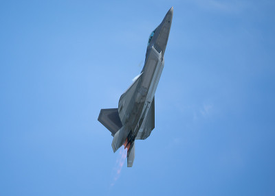 F-22猛禽在美丽的光线下高G爬升，在机翼和加力燃烧室周围形成凝结痕迹