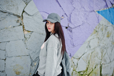 时髦的黑发女孩，灰色的帽子，休闲街头风格的冬天。