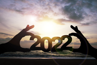 在海滩边，剪影手牵着2022年。准备新年快乐计划，开始新的生活和新的经营理念。