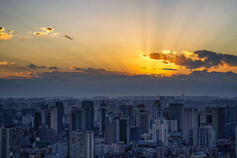 现代城市建筑与浓密的云燃烧在黄昏