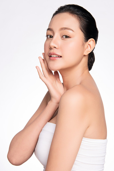 美丽年轻的亚洲女性与干净的新鲜皮肤在白色的背景，面部护理，面部治疗，美容和水疗中心，亚洲女性肖像。