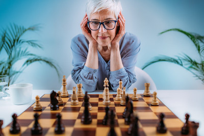 老年妇女下棋。认知康复治疗。