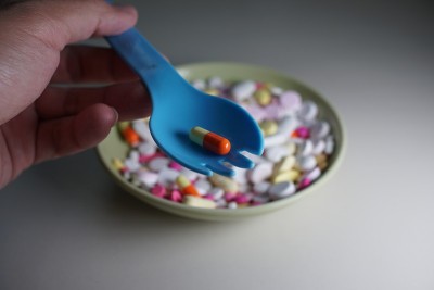 男人的手拿着勺子。用药物。