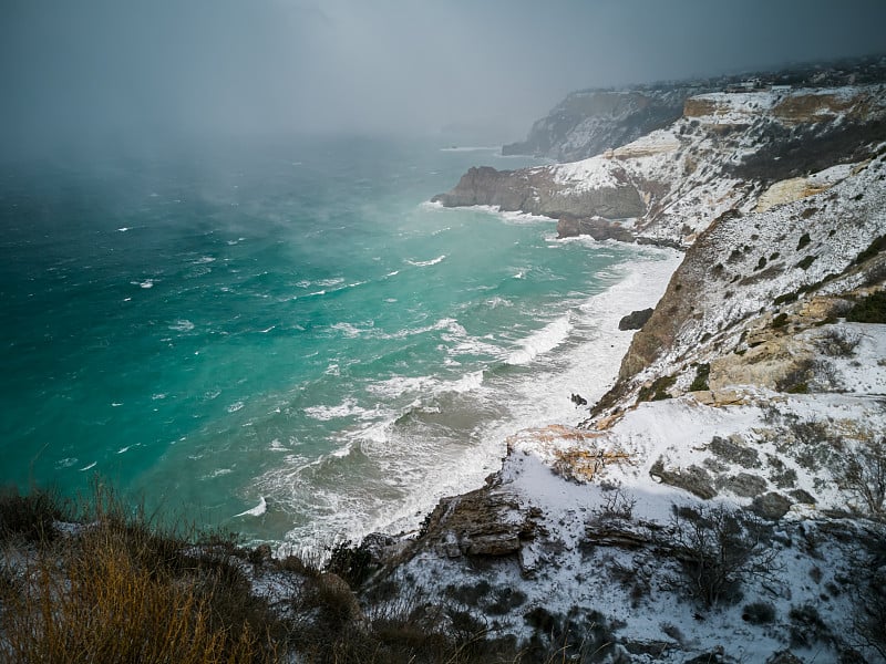 一场暴风雪覆盖了海岸。明亮的绿松石海，狂风，巨浪，明亮的太阳。