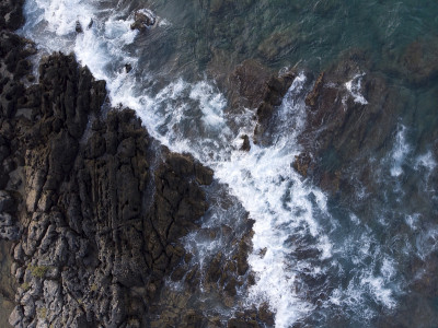空中向上向下的图像，海浪溅起白色泡沫的岩石，岩石悬崖，海岸，克里特岛，希腊。海的图案，背景墙纸。