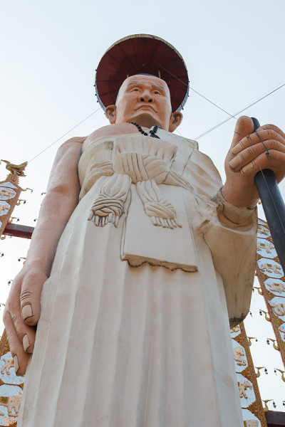 身穿白袍、手持手杖的和尚雕像
