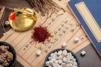 桌上放着古老的中医书籍和药草