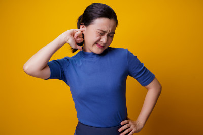 女人搔痒，把一根手指放进耳朵里。