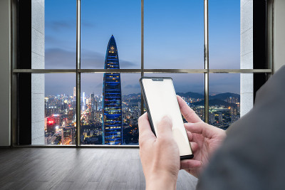 手握手机在深圳的高层建筑