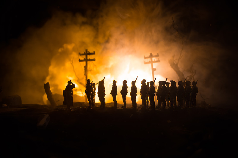 战争的概念。军事剪影在战争雾天空背景战斗场景，世界大战士兵剪影在多云天际线在晚上。废墟城中的战斗。