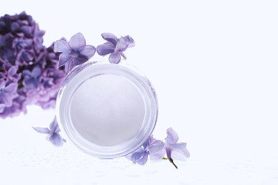 面部和身体皮肤护理。化妆品乳霜白色管与小枝丁香花。家庭护理的水疗。家居嫩肤保湿