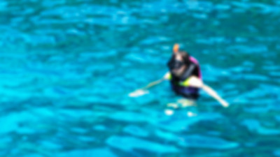 模糊亚洲女人浮潜在清澈的蓝色海洋