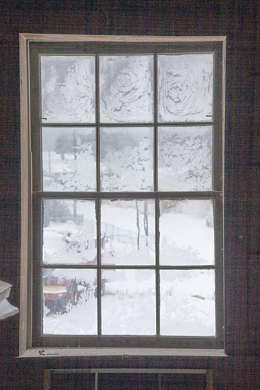 从一扇结霜的玻璃窗看外面的雪景