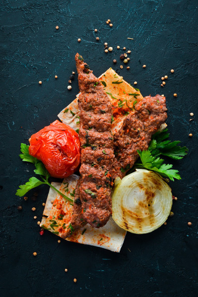 烤羊肉。皮塔饼和香料。在黑色的背景上。前视图。