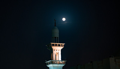 满月之夜清真寺尖塔的背景图像