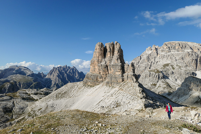 Woman in pink jacket hiking on a narrow path in It