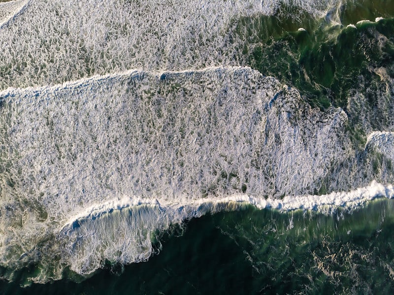 俯视图无人机照片在巴拉达蒂茹卡海滩，里约热内卢de Janeiro，巴西。海浪拍打着白色的浪花，在海