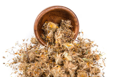一碗干燥的山金车树叶孤立在白色的背景上