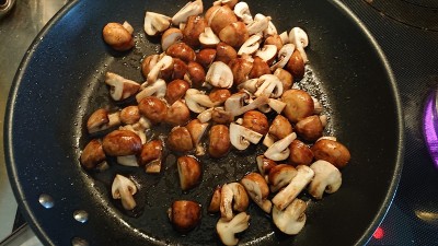 布朗煎蘑菇。烹饪在进步。
