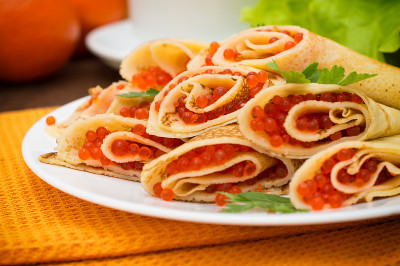 红鱼子酱煎饼卷。俄罗斯菜。平的。Maslenitsa。木制背景。特写镜头