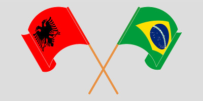 Crossed and waving flags of Albania and Brazil