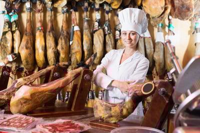 女性工作与伊比利亚火腿在肉店