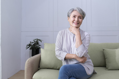 客厅里坐在沙发上的快乐老妇人的肖像