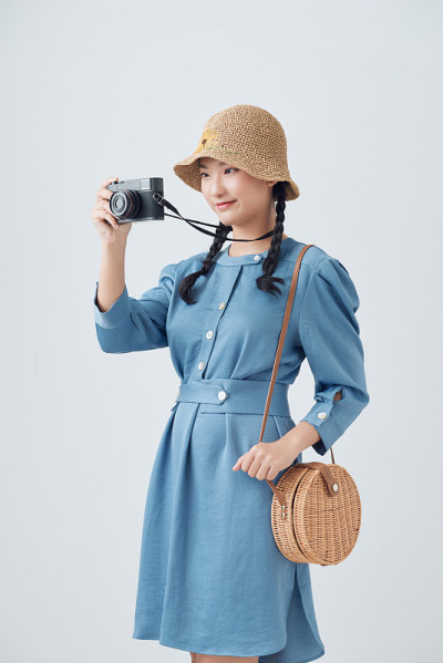 一个微笑的年轻女子的肖像在夏天的帽子站在相机孤立的白色背景