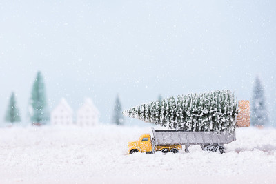 圣诞树上的玩具车卡车都是在雪地里奔跑的自然景观背景