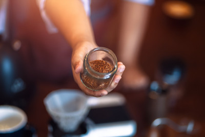 Barista show coffee beans in drip glass.