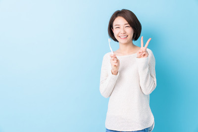 漂亮的亚洲女人用健康的牙齿拿着牙刷，口腔护理