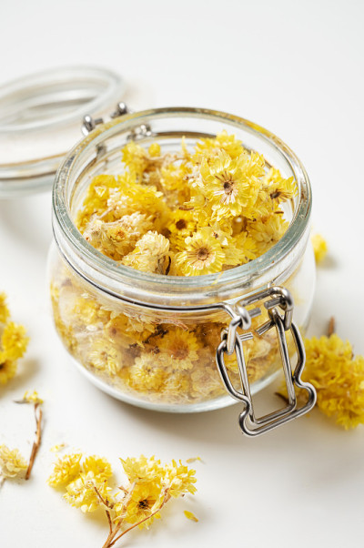 蜡菊italicum。在白色背景下，一个罐子里的黄色干香草花的特写