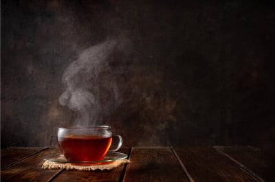 一杯有蒸汽的热茶在黑色的背景
