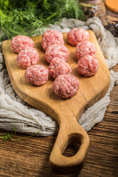 生肉丸放在木砧板上。